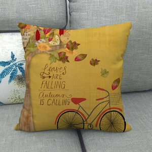 Linen autumn throw pillow featuring a vintage red bicycle and falling leaves on a gray sofa