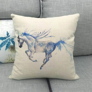 Detailed close-up of watercolor blue horse print on textured beige linen pillowcase