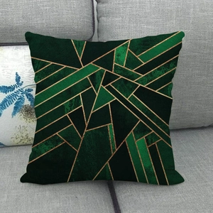 Close-up of abstract geometric patterns on a linen pillowcase atop a grey fabric sofa
