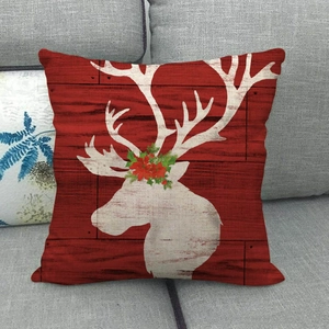 Close-up of a Christmas linen pillowcase featuring a white reindeer silhouette and floral wreath