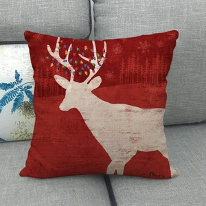 Close-up of red linen Christmas pillow cover with white reindeer and colorful light bulbs