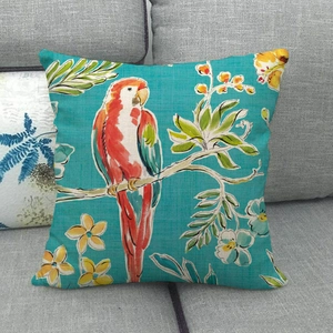 Macro detail of tropical linen pillow case featuring colorful parrot and floral patterns