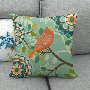 Detailed texture of linen cushion cover featuring artistic orange bird and green leaves