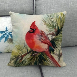 Detailed close-up of watercolor winter bird and pine branch on a linen pillow cover