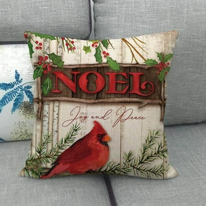 Detail of linen pillow cover with red cardinal and NOEL text on a gray sofa