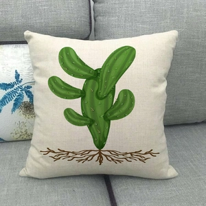Housse de coussin en lin avec imprimé cactus vert sur un canapé en tissu gris moderne
