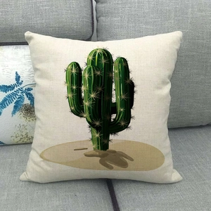 Gros plan d'une housse de coussin en lin avec imprimé cactus sur un canapé gris