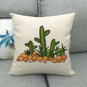Détail d'une taie d'oreiller en lin avec imprimé cactus sur un canapé gris