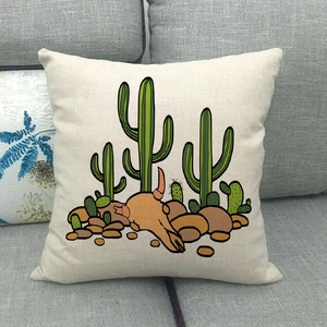 Détail de la housse de coussin en lin cactus avec crâne sur un canapé gris foncé
