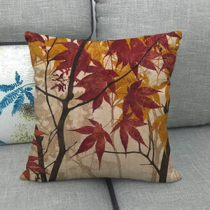Detail of linen cushion cover with oil painting style autumn maple leaves on gray sofa