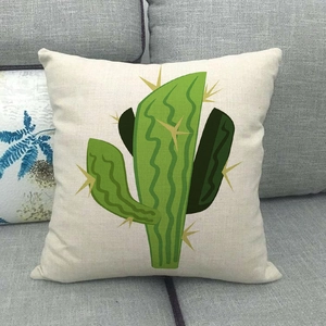 Détail de housse de coussin en lin avec imprimé cactus vert sur canapé gris