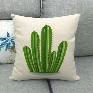 Gros plan sur la housse de coussin en lin avec motif cactus vert sur un canapé gris