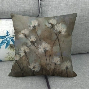 Detail of vintage oil painting floral linen pillowcase on a grey fabric sofa