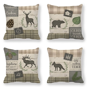 Detail of four linen cushion covers featuring vintage elk and bear forest cabin designs