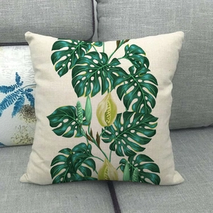 Gros plan sur l'imprimé de feuille de monstera tropicale sur coussin en lin