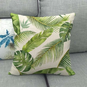 Gros plan sur l'imprimé feuilles tropicales d'une housse de coussin en lin doux