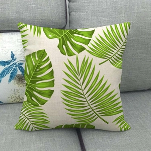 Gros plan du motif de feuilles tropicales sur une housse de coussin en lin naturel
