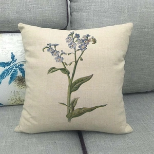 Linen blend throw pillow cover with blue forget-me-not botanical print on grey sofa