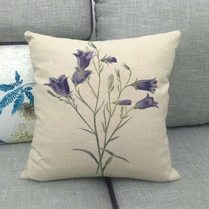 Linen cushion cover with purple floral design on a gray sofa for home decor