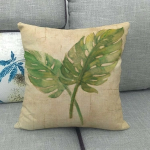 Gros plan d'une taie d'oreiller en lin avec motif feuilles de monstera vertes