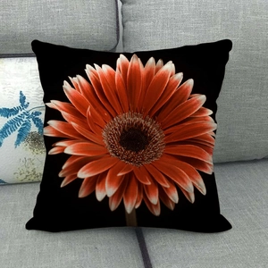 Detailed texture of black linen pillowcase with vibrant orange gerbera daisy print