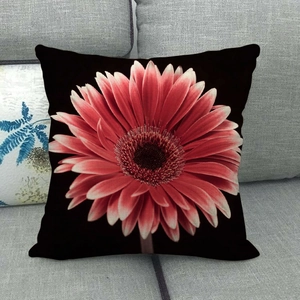 Detailed fabric texture of a black linen pillowcase featuring a pink gerbera daisy