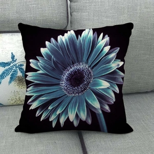 Detailed texture of black linen pillowcase featuring a large cyan gerbera daisy print