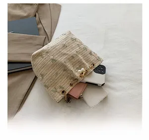Interior storage capacity of the beige woven bucket bag showing phone and wallet