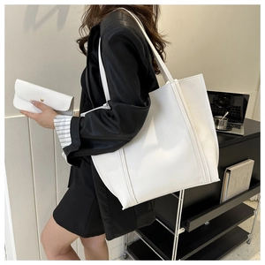 White minimalist PU leather tote bag and matching long wallet shown on a model