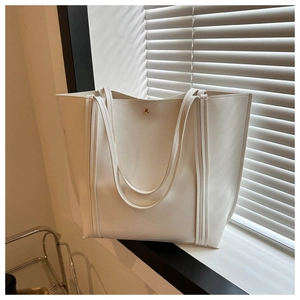 Detail of off-white tote bag with golden metal buckle and matte leather texture