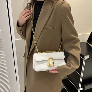 Minimalist white leather crossbody bag with bold gold U-lock and chunky chain strap