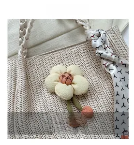 Macro view of woven straw tote bag texture with fabric flower and silk scarf handle