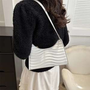 Chic white wavy textured half-moon underarm bag for women worn with a black sweater