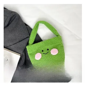 Detail view of grass green plush handbag with embroidered smiley face on lamb wool fabric