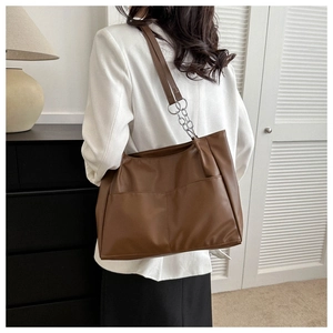 Detail of dark brown PU tote bag with functional pockets and metal chain straps