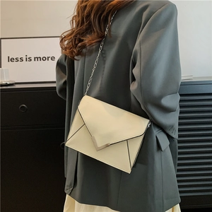 Minimalist creamy white chain shoulder bag with V-shaped metal buckle on model