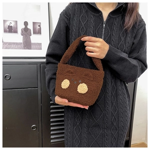 Close-up of cute dark brown plush bear handbag with soft faux fur texture and face detail