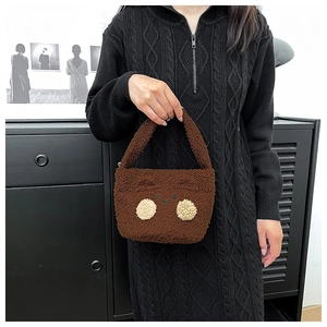 Detail shot of mini plush bear shoulder bag in brown faux fur held by model