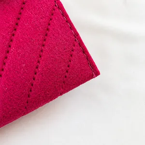 Makrodetail aus hochwertigem magentafarbenem Filzstoff und verstärkten Nähten an der Tasche
