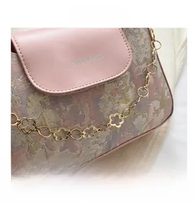 Nahaufnahme der Blumen-Jacquard-Textur mit rosa Lederklappe und Kettenelementen