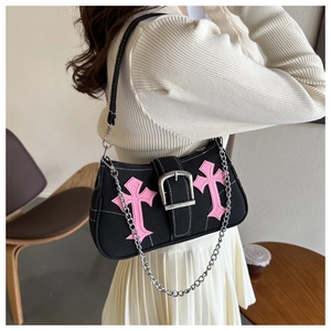 Detail of black canvas shoulder bag with pink gothic cross embroidery and silver buckle