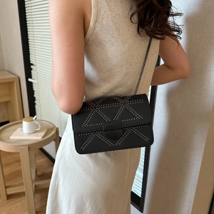 Minimalist black leather crossbody bag with silver studs and metal chain strap