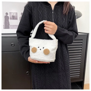 Close-up of white plush shoulder bag with cute cartoon bear face and brown soft cheeks