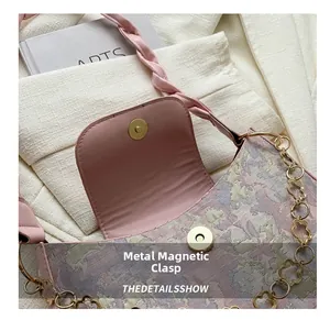Details der rosa floralen Umhängetasche mit Magnetverschluss und goldener Blumenkette