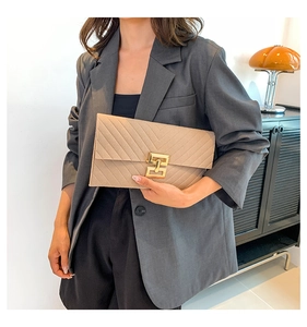 Detailansicht der beigen Umschlag-Clutch mit V-Steppung und goldenem Metallverschluss