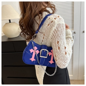 Blue canvas underarm bag with pink cross patch and silver chain strap shown on model