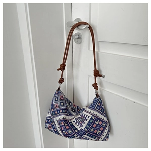 Detail of bohemian geometric jacquard fabric and dark brown braided rope shoulder strap