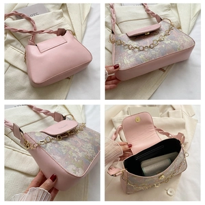 Détail de la bandoulière tressée rose, chaîne florale dorée et motif floral violet du sac