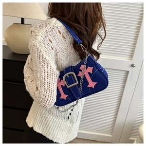 Detail of navy canvas underarm bag with pink gothic cross and silver chain strap