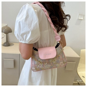 Detail der Schultertasche aus rosa Leder und Blumenstoff mit geflochtenem Riemen